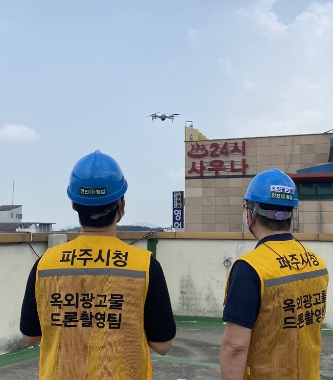 파주시 옥외광고물 담당 공무원이 드론을 활용해 광고물을 점검하고 있다.(사진=파주시 제공)