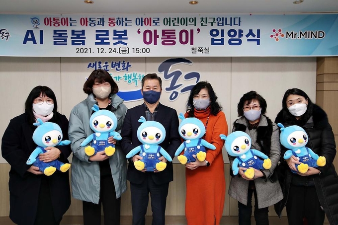 허인화 구청장과 아동 관련 기관 원장들이 AI 돌봄 로봇 아통이를 들고 기념촬영을 하고 있다. ( 사진 = 동구 제공 )