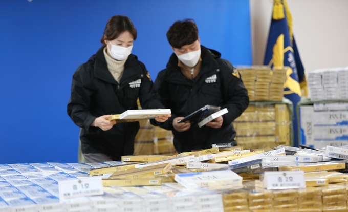 인천해양경찰서 외사계 담당자가 밀수조직들이 반입한 수출용담배 압수물을 확인하고 있다. ( 사진 = 인천해경 제공 )