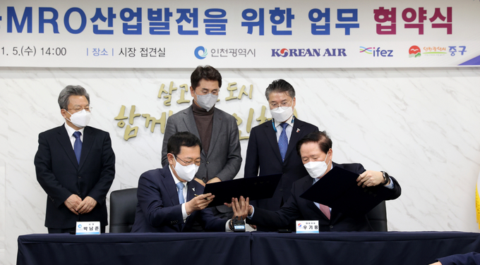 박남춘 인천시장이 5일 '항공MRO산업발전을 위한 업무 협약식'에서 우기홍 대한항공 대표이사와 협약을 체결하고 있다. ( 사진 = 인천시 제공 )