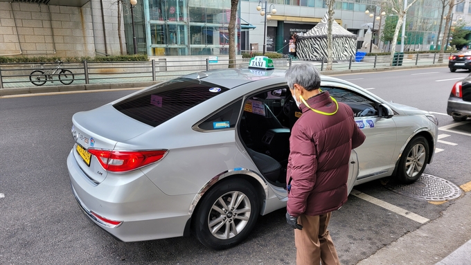 군포시 거주 보훈대상자인 최병홍 어르신이 택시바우처 무료이용 택시에 탑승하고 있다.(사진= 군포시 제공)