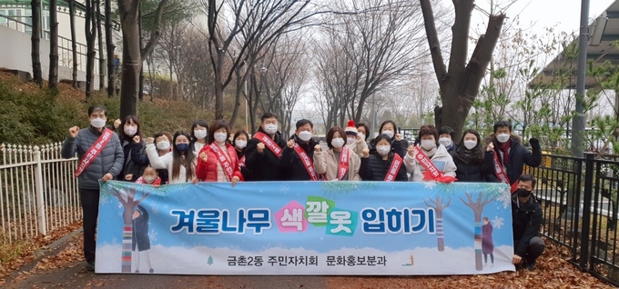 금촌2동 주민자치회 문화홍보분과 위원들이 나무 옷입히기 행사를 마무리했다.(사진=파주시 제공)