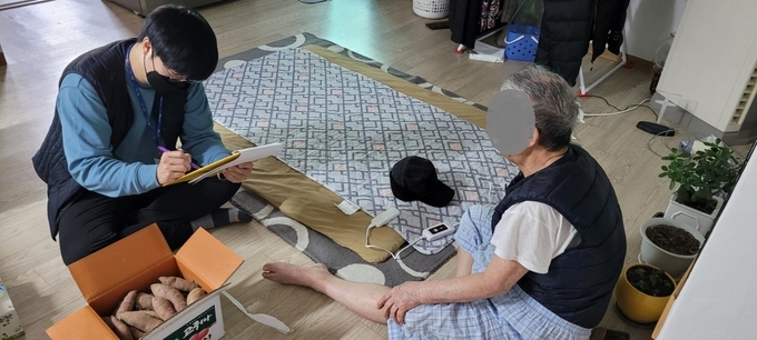 광주시 담당 공무원이 치매등 홀몸어르신 가정집을 방문해 온열매트와 방한모자등을 전달하고 있다.(사진=광주시 제공)