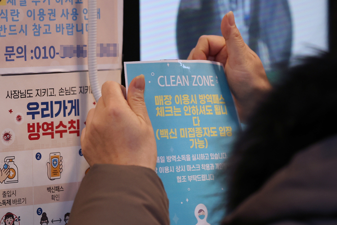 학원, 스터디카페 등에 대한 방역패스 적용이 중단된 5일 오후 수원시 권선구의 한 무인 스터디카페에서 주인이 백신 미접종자도 입장이 가능하다고 알리는 안내문을 붙이고 있다 (사진=연합뉴스/자료사진)