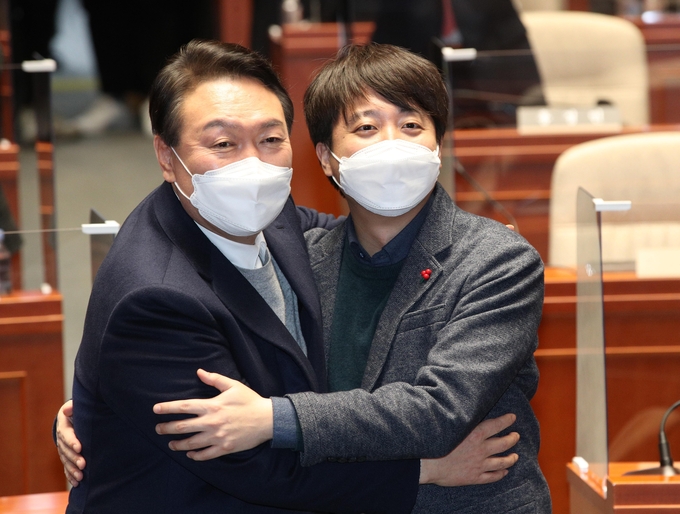 극한 대치 끝에 전격 화해한 국민의힘 윤석열 대선 후보와 이준석 대표가 6일 저녁 국회에서 열린 의원총회에서 손을 맞잡고 있다. (사진=국회사진기지단/연합뉴스)