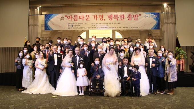 지난해 열린 장애인 가정 합동결혼식에서 신랑, 신부와 가족들이 환한 표정으로 사랑의 포즈를 취하고 있다.