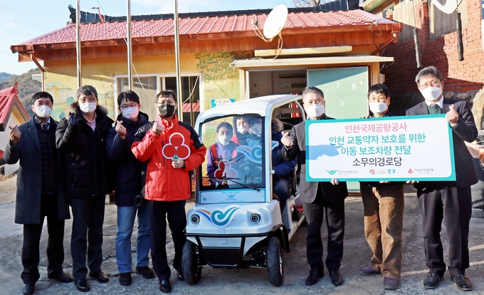 임병기 인천공항 경영본부장이 섬 교통약자 이동편의를 위한 보조차량을 전달한 뒤 홍인성 중구청장, 지역주민들과 사진촬영을 하고 있다. ( 사진 = 인천공항공사 제공 )