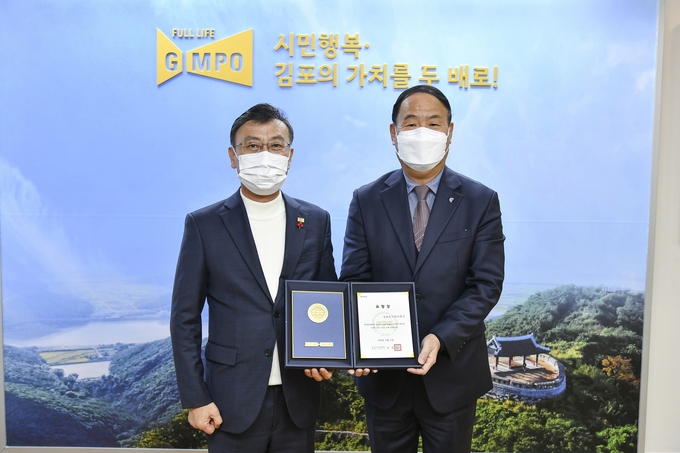김동석 김포도시공사 사장(오른쪽)이 경기도로부터 안전유공 표창을 받은 후 정하영 시장과 함께 기념촬영을 하고 있다.(사진=김포도시공사 제공)