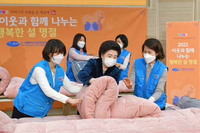장길자 회장과 회원들이 소외이웃들의 따뜻한 설 명절과 희망찬 새해를 기원하며 포근한 극세사 이불을 정성껏 준비하고 있다. (사진=위러브유 제공)