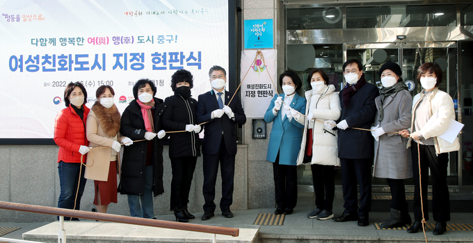 27일 홍인성 구청장과 여성참여단이 함께 구청사 입구에서 여성친화도시 지정 현판식을 하고 있다. ( 사진 = 중구 제공 )