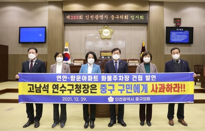 인천시 중구의회 의원들이 본회의장에서 현수막을 들고 고남석 연수구청장의 사과를 요구하고 있다. ( 사진 = 중구 제공 )