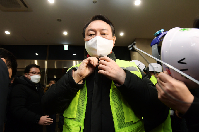 국민의힘 윤석열 대선 후보가 새해 첫날인 1일 0시 대외 교역 최전선인 인천신항 선광신컨테이너터미널(SNCT)을 찾아 현장을 둘러보기에 앞서 형광 안전조끼를 입고 있다. (사진=공동취재/연합뉴스)