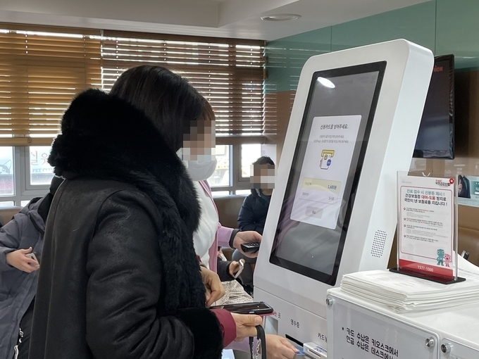 한 손에는 전화를 들고 방문 환자를 안내하고 있는 호흡기전담클리닉 직원의 모습. (사진=김한별 기자)