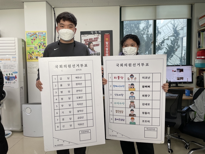 한국피플퍼스트에서 제작한 그림투표용지 예시를 보여주고 있는 김대범 동료상담가(좌)와 박경인 동료지원가(우) (사진=김한별 기자) 