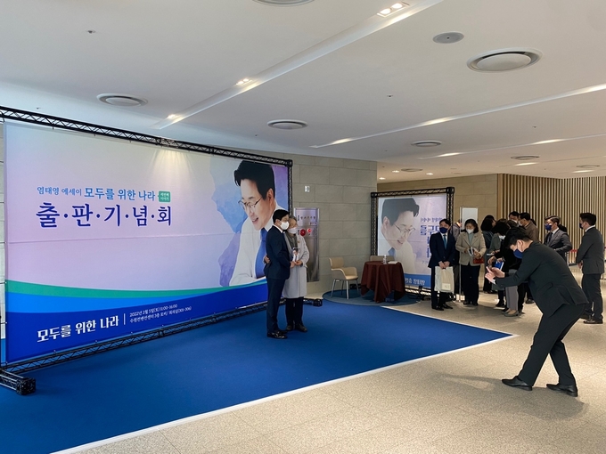 염태영 수원특례시장이 출판기념회에 참석한 사람들과 사진을 찍고 있다. (사진= 이명호 기자)