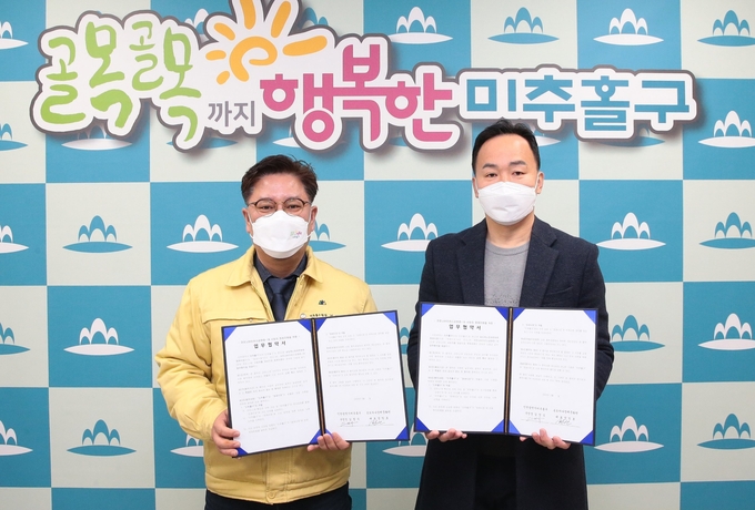 김정식 구청장(왼쪽)이 송도하나장례문화원과 체결한 업무협약서를 들어보이고 있다. ( 사진 = 미추홀구 제공 )