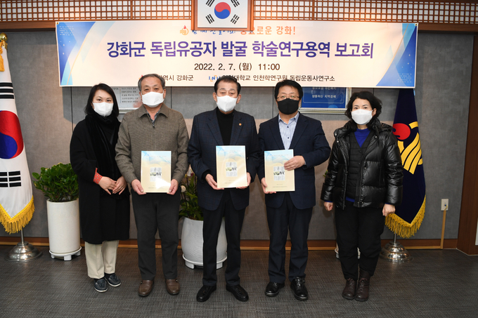7일 열린 보고회에서 유천호 군수(가운데)와 최용규 인천대 이사장(오른쪽 두번째) 등이 발굴 보고서를 들고 기념촬영을 하고 있다. ( 사진 = 강화군 제공 )