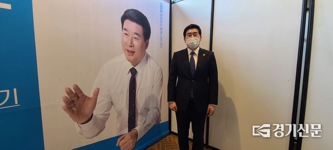 강준모 의원이 자신의 사진 옆에서 본지를 위해 포즈를 취해 주었다. (사진=문석완 기자)