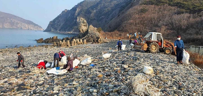 덕적 주민들이 능동해변 자갈마당에서 쓰레기를 수거하고 있다. ( 사진 = 옹진군 제공 )