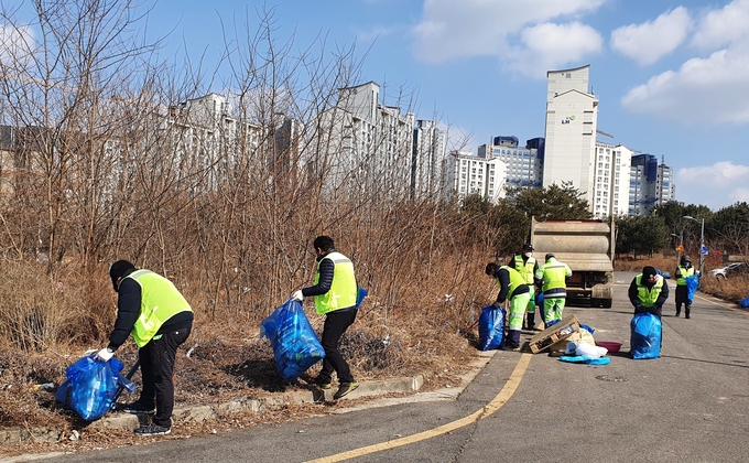 영종동 환경미화원과 주민들이 도로주변 쓰레기 수거작업을 하고 있다. ( 사진 = 중구 제공 )