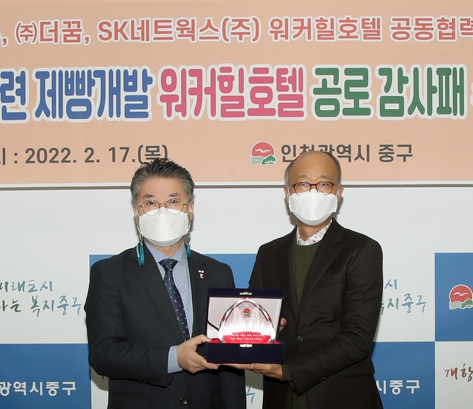 홍인성 중구청장(왼쪽)이 SK네트웍스 워커힐호텔 관계자에게 짜장빵 개발에 기여한 공로로 감사패를 전달하고 있다. ( 사진 = 중구 제공 )