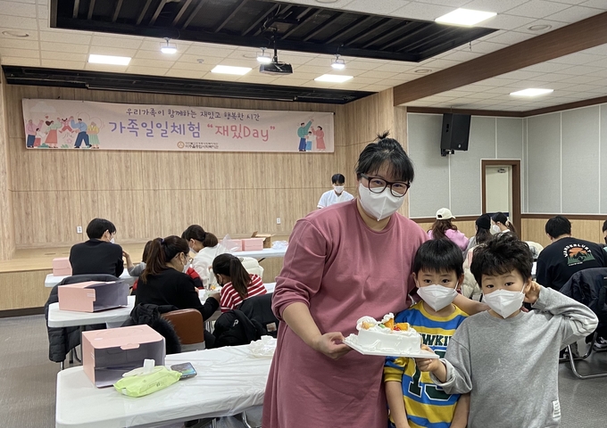 재밌Day행사에 참가한 가족이 직접 만든 케이크를 들어보이고 있다. ( 사진 = 미추홀구 제공 )