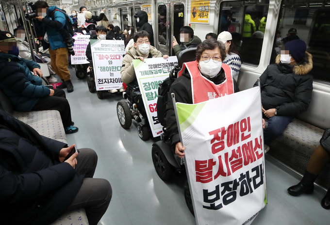 전국장애인차별철폐연대 관계자들이 지난 1월 3일 오후 서울 지하철 5호선 광화문역에서 열린 '기획재정부 장애인권리예산 반영 촉구에 대한 입장발표 기자회견'을 마친뒤 열차에 탑승해 장애인 이동권 보장을 촉구하는 피케팅을 하고 있다. (사진=연합뉴스)