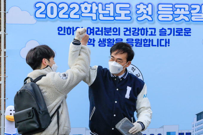 개강일 조명우 총장이 등교 중인 한 학생과 축하 및 격려 의미의 하이파이브를 하고 있다. ( 사진 = 인하대 제공 )