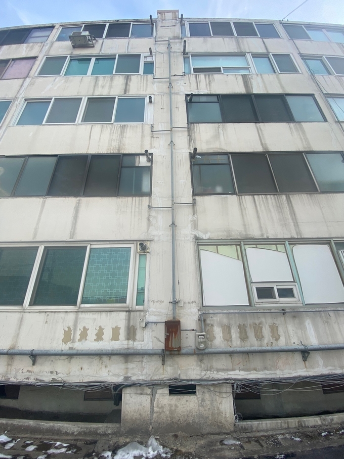 아파트 하부는 균열이 진행되고 있었고 외벽에는 녹슨 관이 길게 늘어서있다. (사진= 이명호 기자)