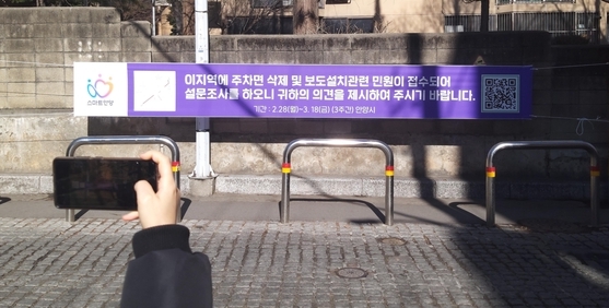 안양시 안양9동 프라자아파트 담장가 주차장 존치여부에 대해 첫 설문조사 벌이고 있다.(사진=안양시 제공)