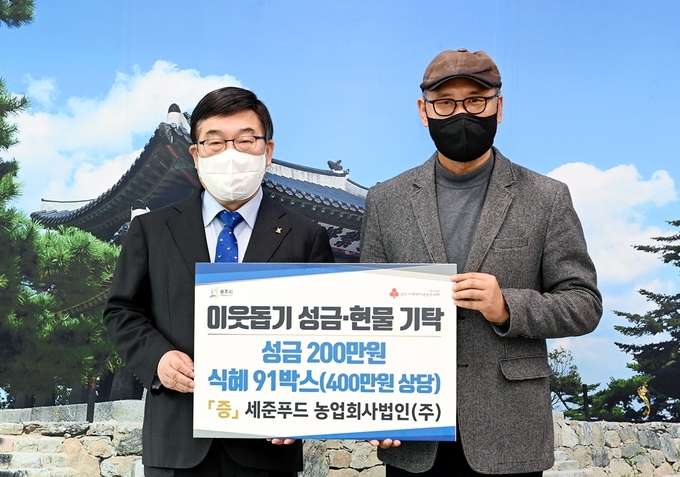 세준푸드 문완기 대표는 어려운이웃을 위해 써달라며 신동헌광주시장에게 현금과 현물을 기탁하고 있다.(사진=광주시 제공)