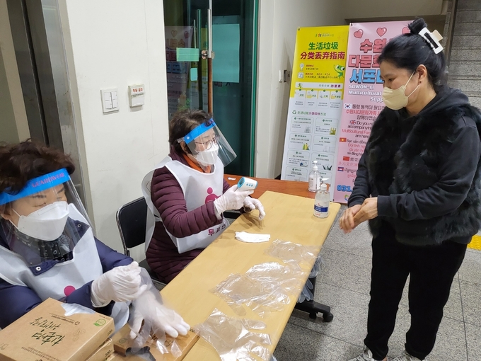 수원시 화서1동 주민센터(3층, 대회의실)에 위치한 화서1동 제1투표소에서 입장 전 한 시민이 발열체크를 받고있다. (사진=김한별 기자)