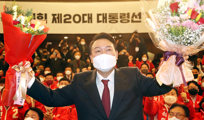 윤석열 제20대 대통령 당선인이 10일 새벽 서울 여의도 국회도서관에 마련된 '국민의힘 제 20대 대통령선거 개표상황실'에서 꽃다발을 들고 포즈를 취하고 있다. (사진=국회사진기자단/연합뉴스 제공)