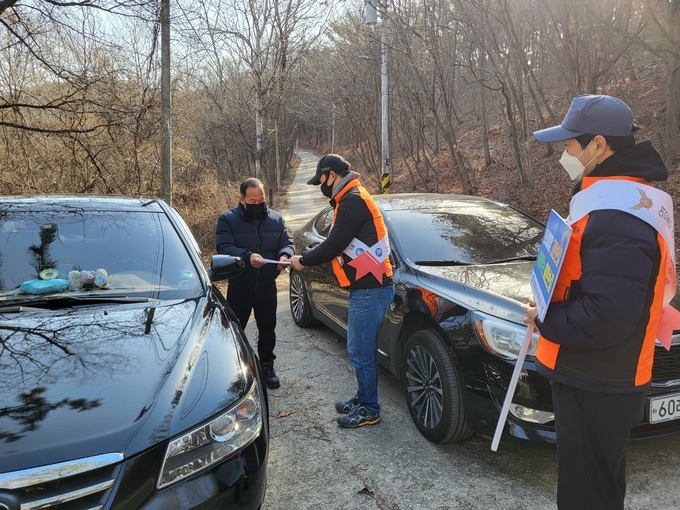 산불예방 순찰대원들이 등산객들에게 산불예방 홍보안내문을 전달하고 있다. ( 사진 = 영종소방서 제공 )