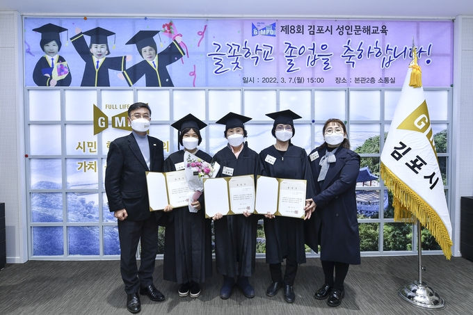 김포시 성인문해교육 글꽃학교 졸업식에서 졸업장을 받은 어른신들이 정하영 시장(완쪽 첫번째)과 함께 기념촬영을 하고 있다. (사진=글꽃학교 제공)
