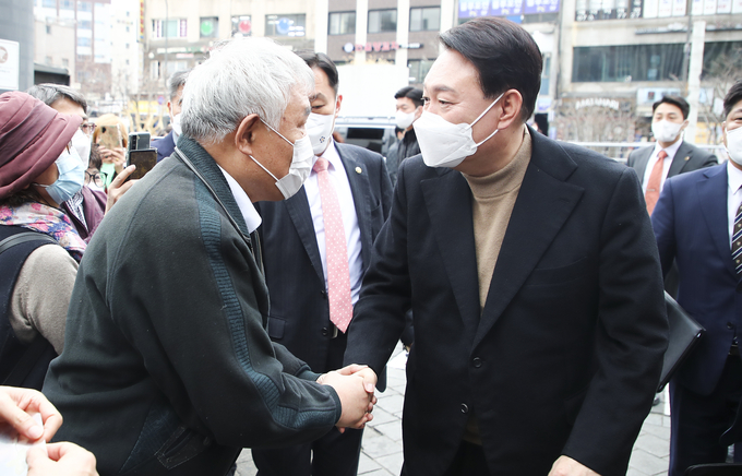 윤석열 대통령 당선인이 14일 당선 이후 첫 외부 공식일정으로 서울 남대문 시장을 찾아 상인 및 시민들과 인사를 나누고 있다. (사진=국회사진기자단/연합뉴스 제공)