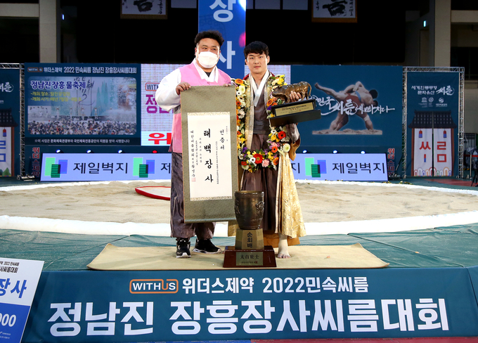14일 전남 장흥군 장흥실내체육관에서 열린 위더스제약 2022 민속씨름 정남진 장흥장사씨름대회에서 태백장사에 등극한 문준석(수원특례시청)이 이충엽 감독(왼쪽)과 기념사진을 찍고 있다. (사진=대한씨름협회 제공)