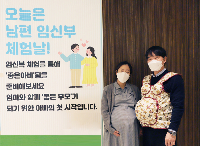 임산부와 임신체험 프로그램에 참여한 남편이 체험 중 기념촬영을 하고 있다. (사진=분당차여성병원 제공) 