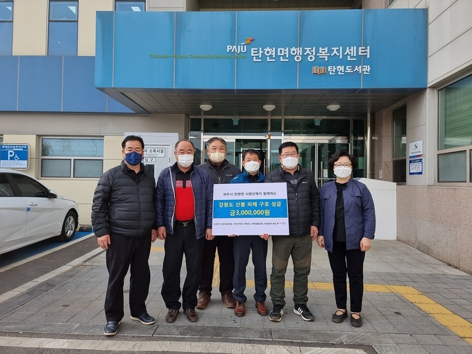 파주시 탄현면 5개 사회단체 회원들은 지난 17일 파주시 탄현면에 강원도 산불 피해 복구 성금 300만 원을 기탁하고 있다.(사진=파주시 제공)
