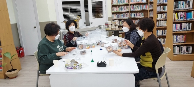 그림책읽기 회원들이 초컬릿 도넛 키트를 만들고 있다. ( 사진 = 남동구 제공 )