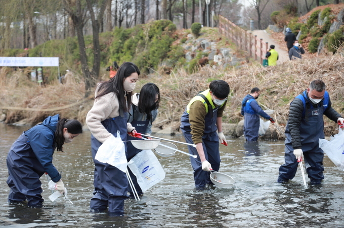 삼성전자 임직원들과 NGO 관계자들이 수원 원천리천 삼성교부터 백년교에 이르기까지 총 3Km에 달하는 구간의 수변 및 수중 정화활동을 펼치고 있다. (사진=삼성전자 제공)