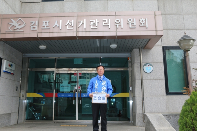 김포시 선관위에서 시장 예비후보로 등록을 마치고 나온 조승현 더불어민주당 부대변인이 기념촬영을 하고 있다. (사진=조승현 예비후보 사무실 제공)