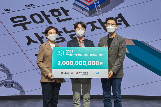 우아한형제들 김범준 대표(가운데)와 사랑의열매 신혜영 본부장(왼쪽), 사단법인 점프 이의헌 대표가 지난 26일 서울 코엑스에서 ‘2022년 우아한 사장님 자녀 장학금’ 수여식을 열고 기념촬영을 하고 있다. (사진=우아한형제들 제공)