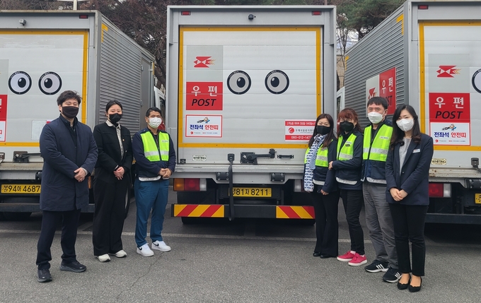 봄철 졸음운전 방지를 위해 한국도로공사 수도권본부와 우체국물류지원단이 배소차량에서 잠깨우는 왕눈이를 부착한 후 기념촬영을 하고 있다.(사진=도로공사 제공)