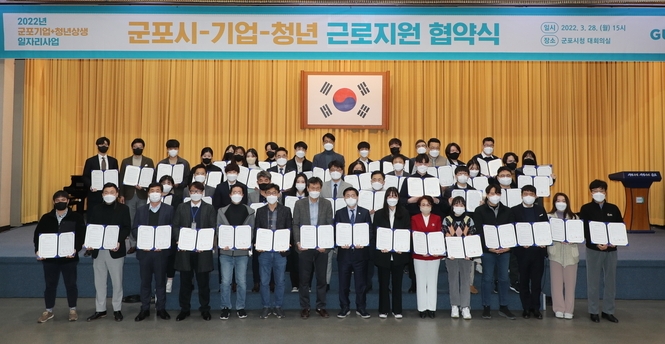 군포시+기업+청년, 상생 일자리사업’ 근로지원 협약식이 지난 28일 군포시청에서 열려 한대희 시장(제1열 가운데 정장 차림)과 참여기업, 참여청년 등이 협약서을 들고 기념촬영을 하고 있다.(사진=군포시 제공)