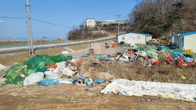 인천 용유동(무의도) 해안도로 건설현장 사무실 공터에 폐기물이 방지돼 있다. ( 사진 = 박영재 기자 )