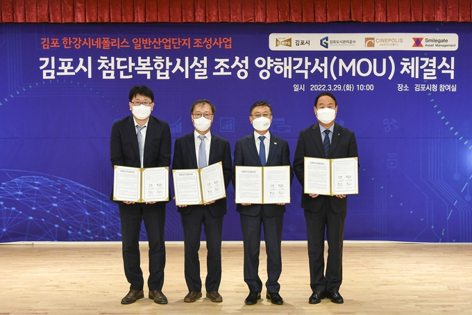 정하영 김포시장, 이찬열 스마일게이트자산운용 대표이사, 김동석 김포도시관리공사 사장, ㈜한강시네폴리스개발 대표이사가 지난 29일 김포시청에서 첨단복합시설 조성 양해각서(MOU)를 체결하고 기념사진을 찍고 있다.(사진=김포시 제공)