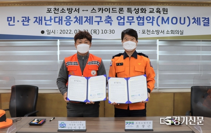 조창근 포천소방서장(오른쪽)과 이창진 스카이 드론 특성화 연구원 단장이 협약서를 들어보이고 있다. (사진=포천소방서 제공)
