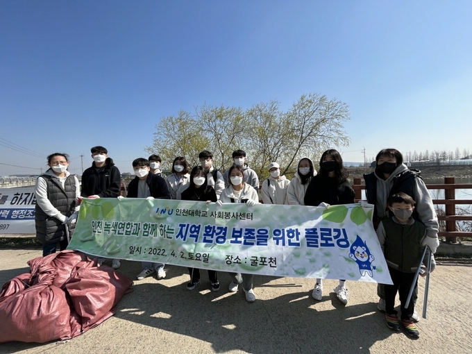 굴포천에서 플로깅 봉사활동을 벌인 인천대 학생들과 인천녹색연합 회원들. ( 사진 = 인천대 제공 )