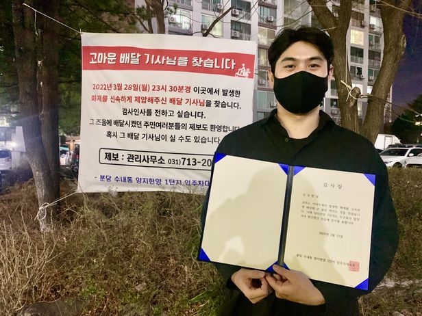 지난달 28일 성남시의 한 아파트에서 발생한 화재를 진압한 배달기사 김상현(31)씨가 주민들이 마련한 감사장과 선물을 받았다. (사진=분당 수내동 양지한양 1단지 입주자대표회의 제공)